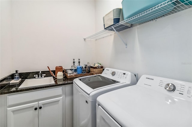 laundry room with cabinets, washing machine and clothes dryer, and sink