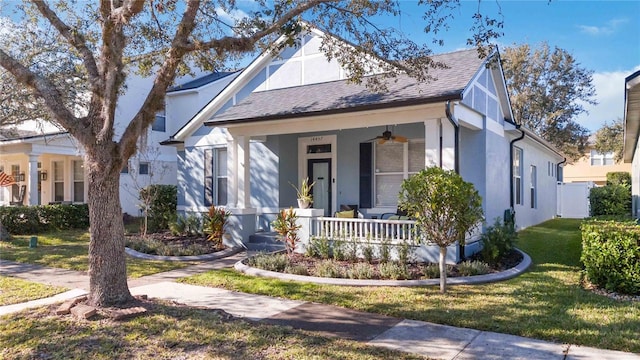 view of front of property with ceiling fan, a porch, and a front yard