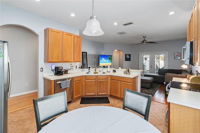 kitchen with sink, light tile patterned floors, appliances with stainless steel finishes, decorative light fixtures, and french doors