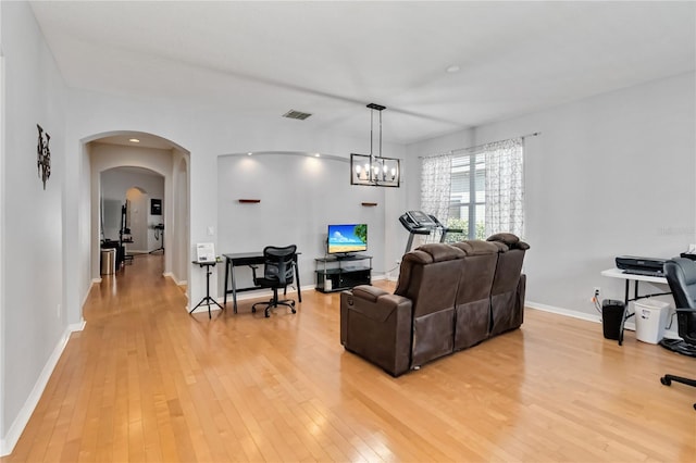 living room with light hardwood / wood-style floors and a chandelier