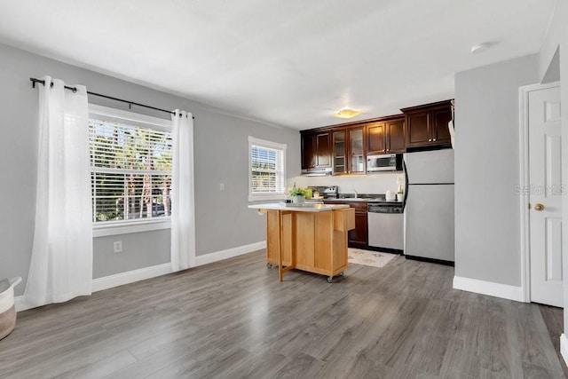 kitchen with appliances with stainless steel finishes, light hardwood / wood-style floors, and sink