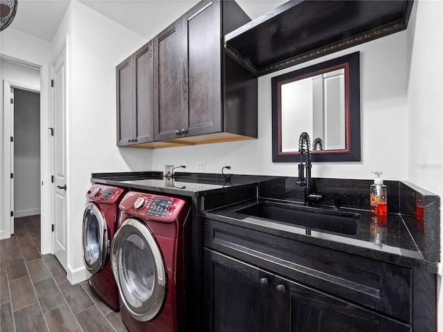 laundry area featuring cabinets, separate washer and dryer, and sink