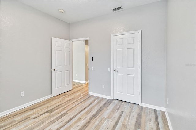 unfurnished bedroom with a closet and light hardwood / wood-style floors