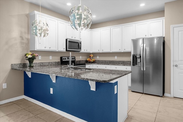 kitchen with kitchen peninsula, stainless steel appliances, white cabinets, and pendant lighting