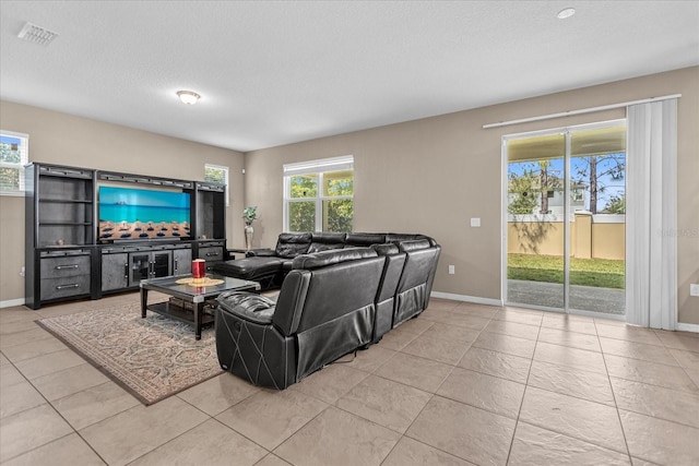 living room with a textured ceiling and light tile patterned floors