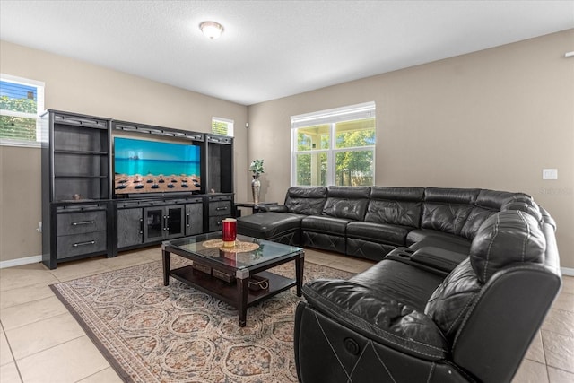 living room featuring a textured ceiling, light tile patterned floors, and plenty of natural light