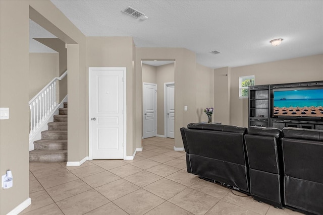 living room featuring a textured ceiling and light tile patterned flooring