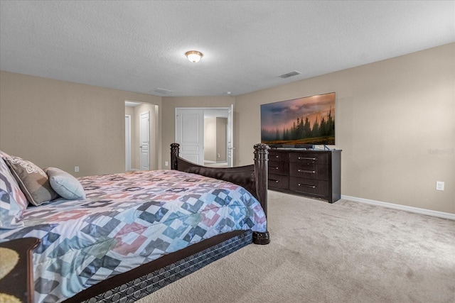 bedroom with a textured ceiling and light carpet