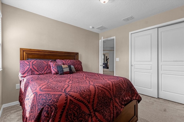 carpeted bedroom with a closet and a textured ceiling