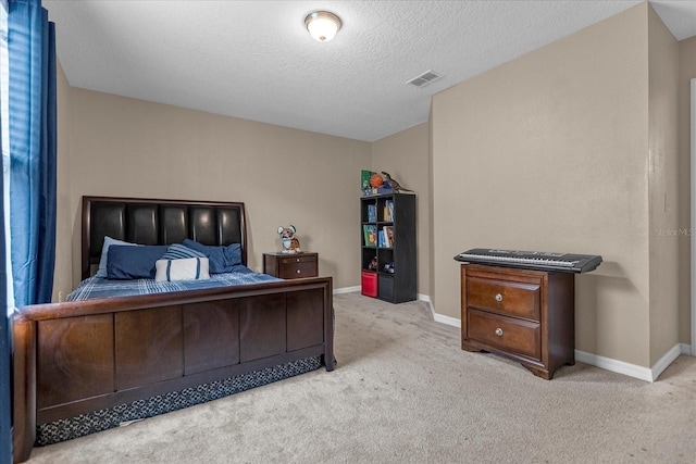 bedroom with a textured ceiling and light carpet