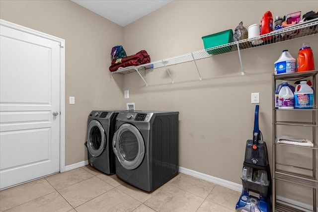 clothes washing area with washer and clothes dryer and light tile patterned floors