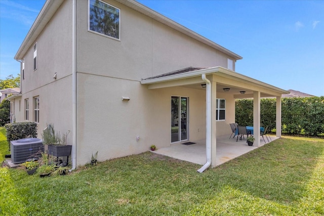 rear view of house featuring a patio, central AC, and a lawn