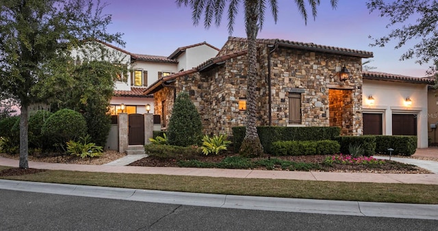 mediterranean / spanish home featuring a garage