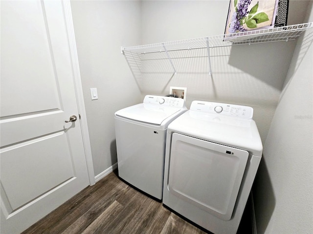 washroom with washing machine and clothes dryer and dark hardwood / wood-style floors