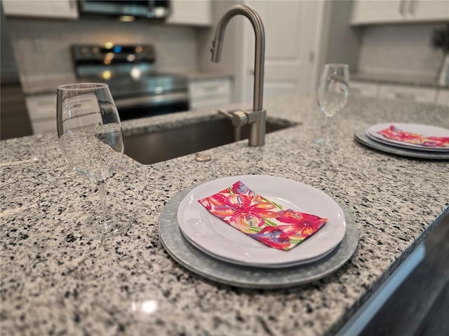 details with sink, range with electric cooktop, and light stone countertops