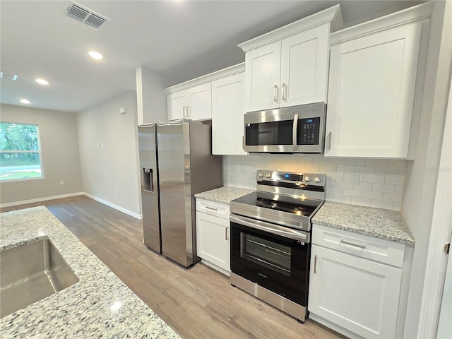 kitchen featuring stainless steel appliances, decorative backsplash, white cabinetry, and sink