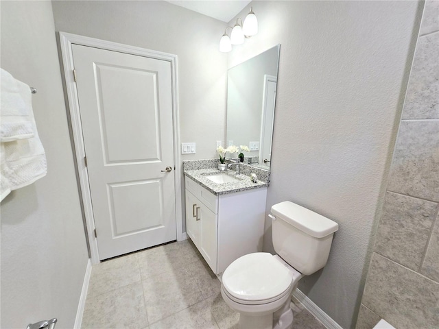 bathroom featuring tile patterned flooring, vanity, and toilet