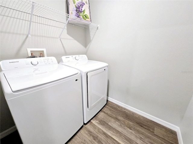 clothes washing area with independent washer and dryer and hardwood / wood-style flooring