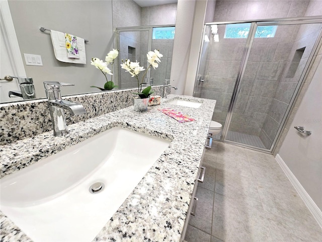 bathroom with toilet, tile patterned flooring, a shower with door, and vanity