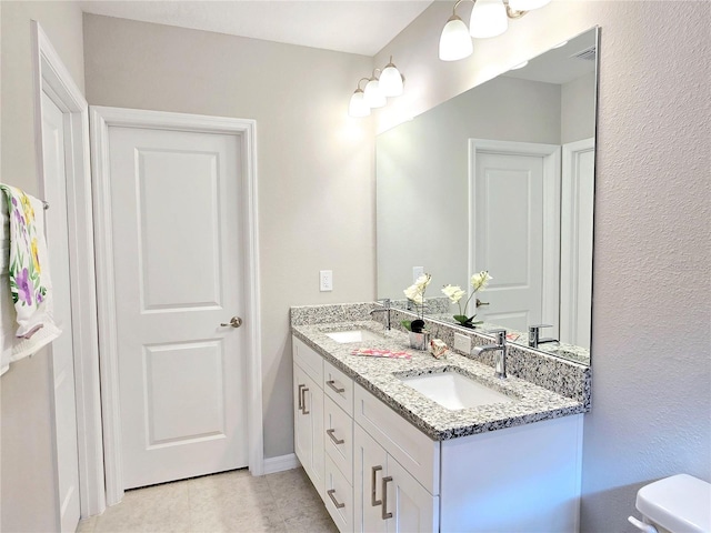 bathroom featuring tile patterned floors, vanity, and toilet