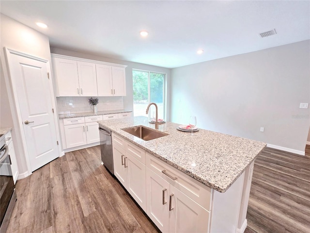 kitchen featuring white cabinets, stainless steel dishwasher, a kitchen island with sink, and sink