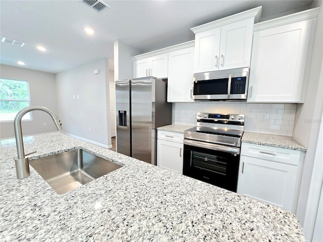 kitchen featuring appliances with stainless steel finishes, white cabinetry, and sink