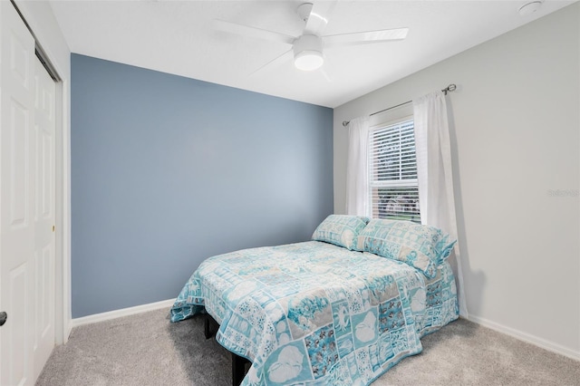 carpeted bedroom featuring ceiling fan and a closet