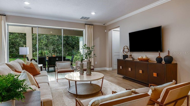 living room featuring a textured ceiling, ornamental molding, and light hardwood / wood-style floors