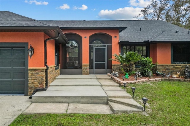 doorway to property featuring a yard and a garage