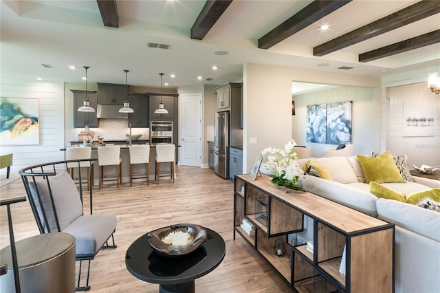 living room with light hardwood / wood-style flooring and beam ceiling