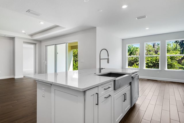 kitchen featuring stainless steel dishwasher, a sink, visible vents, and plenty of natural light