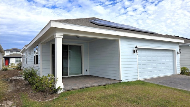 exterior space with solar panels, a yard, and a garage