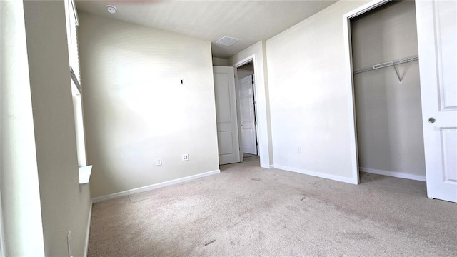 unfurnished bedroom featuring a closet and light colored carpet