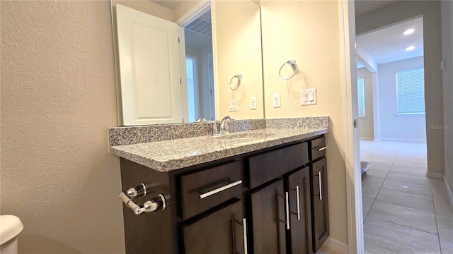 bathroom featuring toilet, vanity, and tile patterned flooring