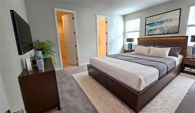 carpeted bedroom featuring ensuite bath