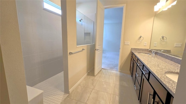 bathroom with vanity, a tile shower, and tile patterned flooring