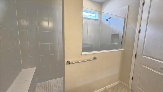 bathroom featuring tile patterned flooring and tiled shower