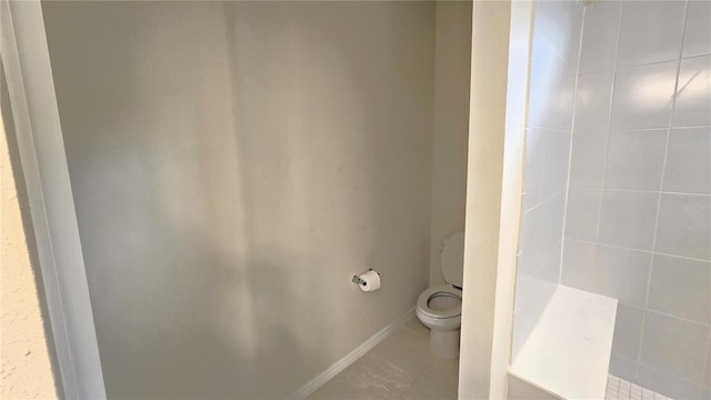 bathroom featuring toilet, tile patterned floors, and walk in shower