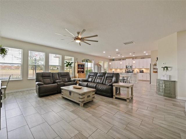 living room featuring ceiling fan and a wealth of natural light