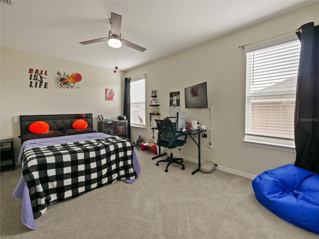 bedroom with ceiling fan, multiple windows, and carpet