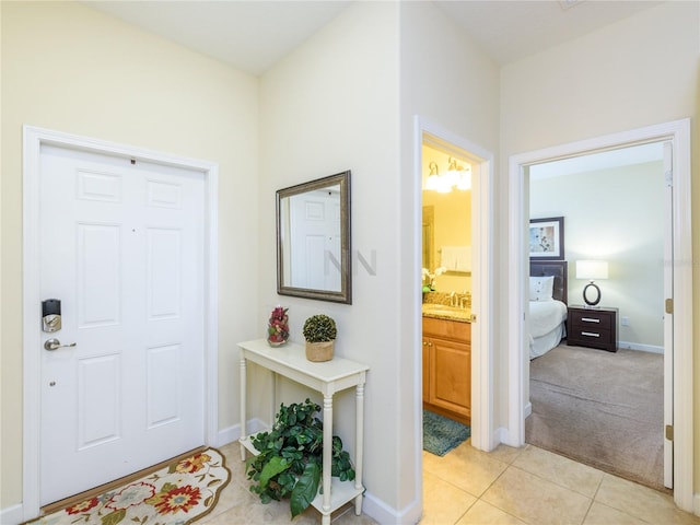 entrance foyer with light tile patterned floors and sink