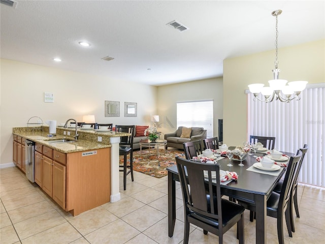 dining area with sink, light tile patterned floors, and a chandelier