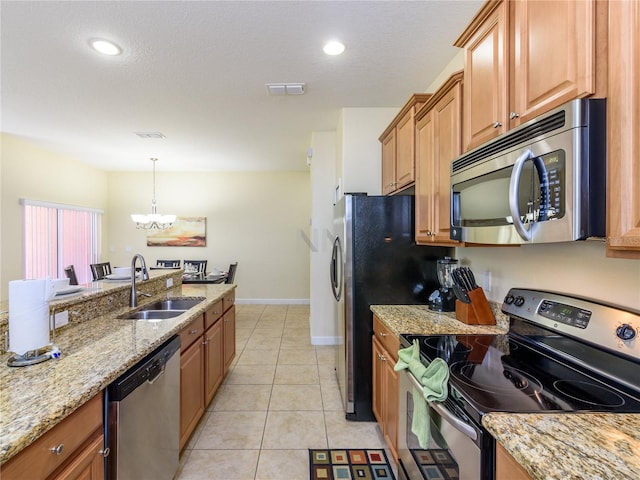 kitchen with sink, light tile patterned flooring, appliances with stainless steel finishes, light stone counters, and a chandelier