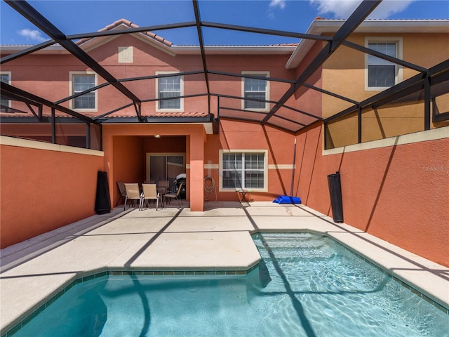 back of house featuring glass enclosure and a patio