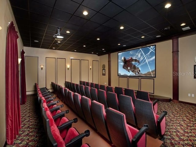 carpeted home theater featuring ceiling fan and a drop ceiling