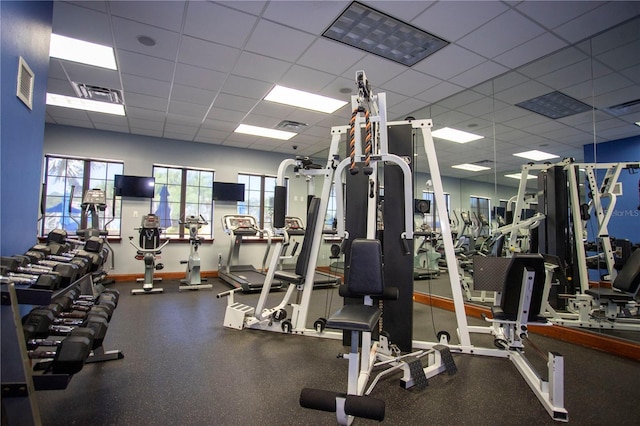 workout area featuring a paneled ceiling and plenty of natural light