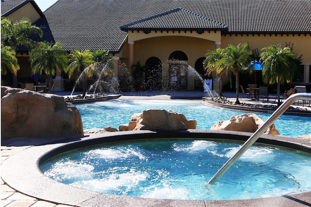 view of swimming pool featuring pool water feature and a community hot tub