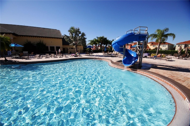 view of pool with a patio area and a water slide