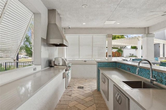 kitchen with sink, a textured ceiling, and premium range hood