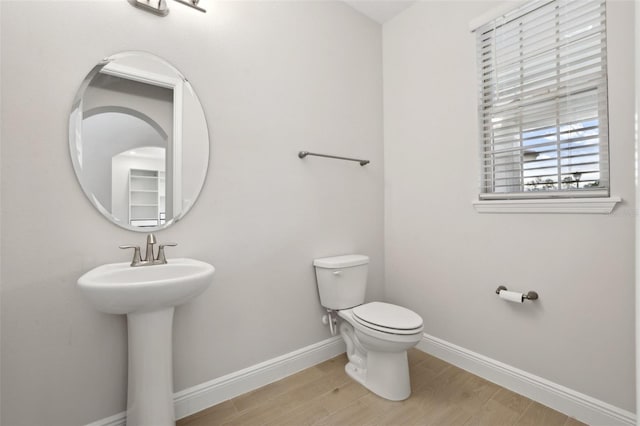 bathroom with toilet, hardwood / wood-style flooring, and sink